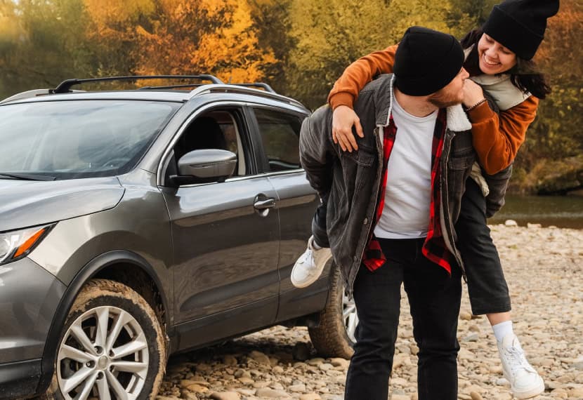 man and woman standing outside of new vehicle