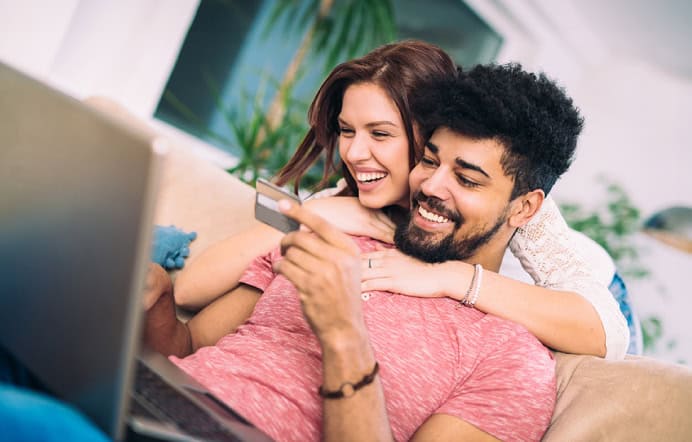 couple embracing looking at debit card