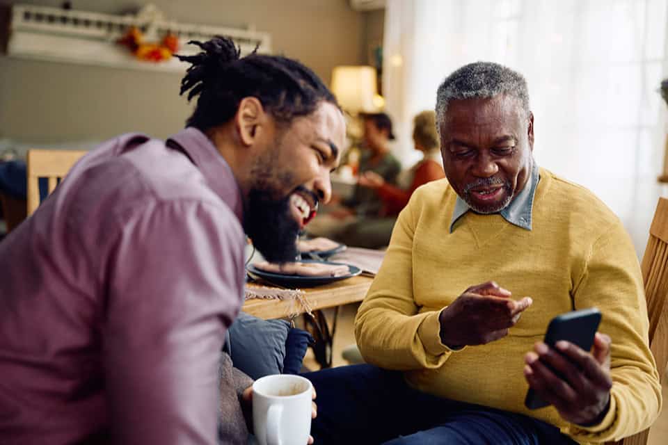 two men looking at mobile device digital services