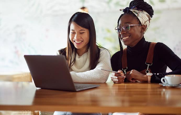 two women sharing a laptop