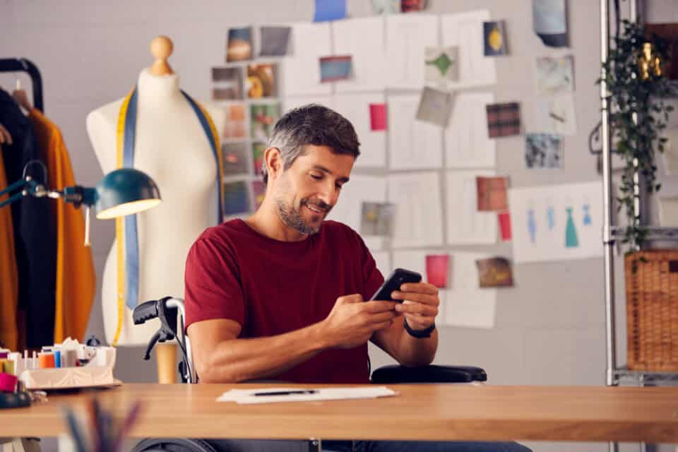 man sitting in wheelchair with mobile device