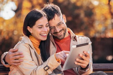 a woman and man looking on a tablet