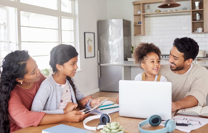 mom, dad and two kids sitting around a table talking